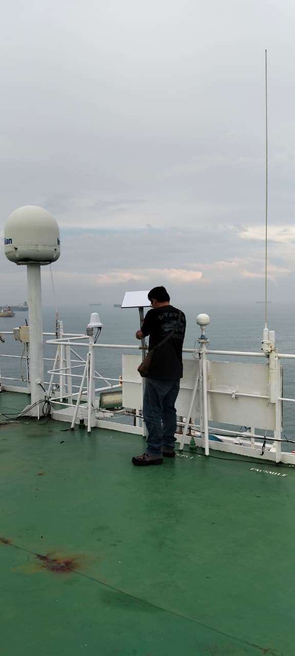 Teknisi mengarahkan antena di kapal
